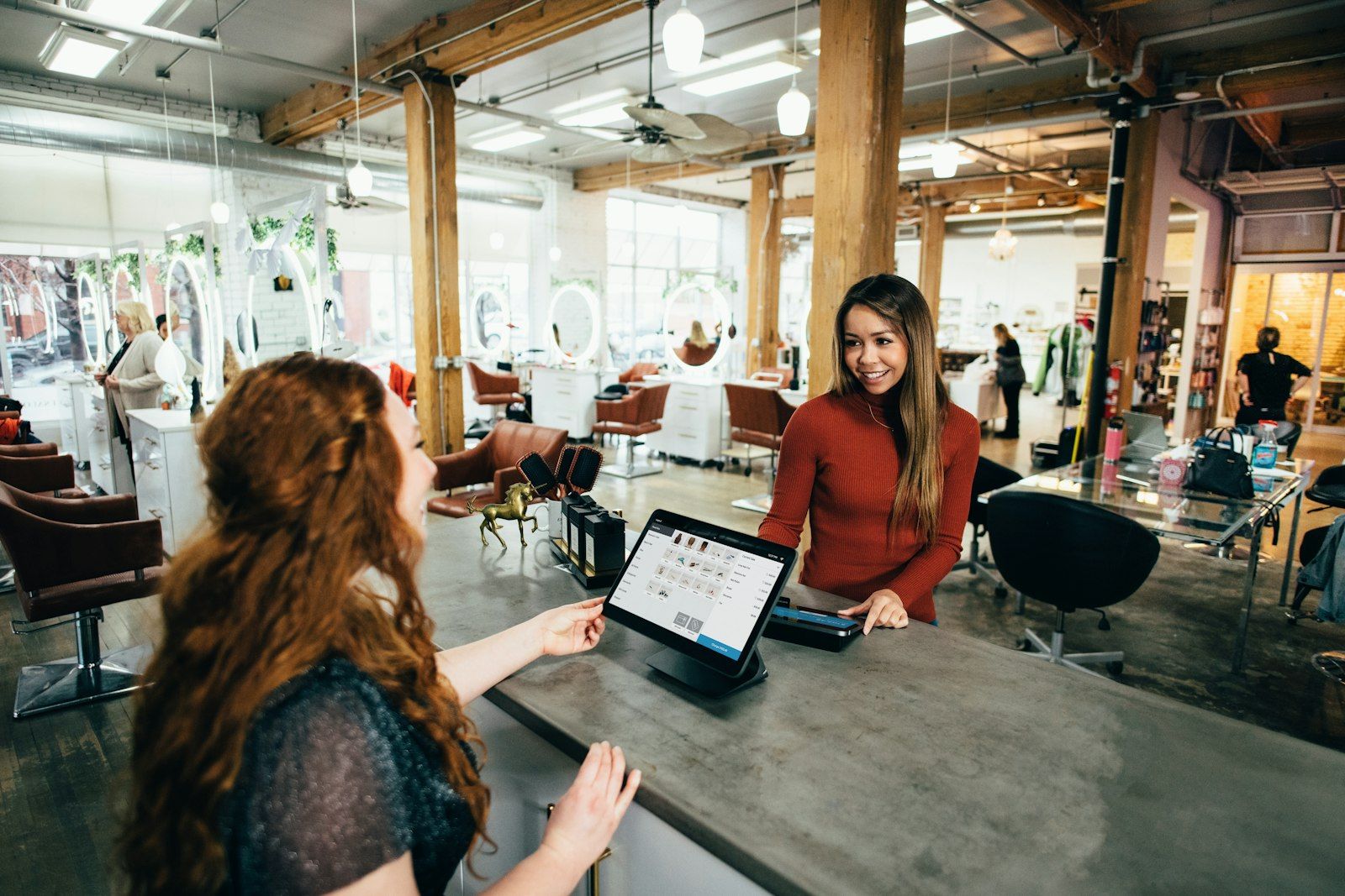 Deux personnes au comptoir d'une boutique devant une tablette